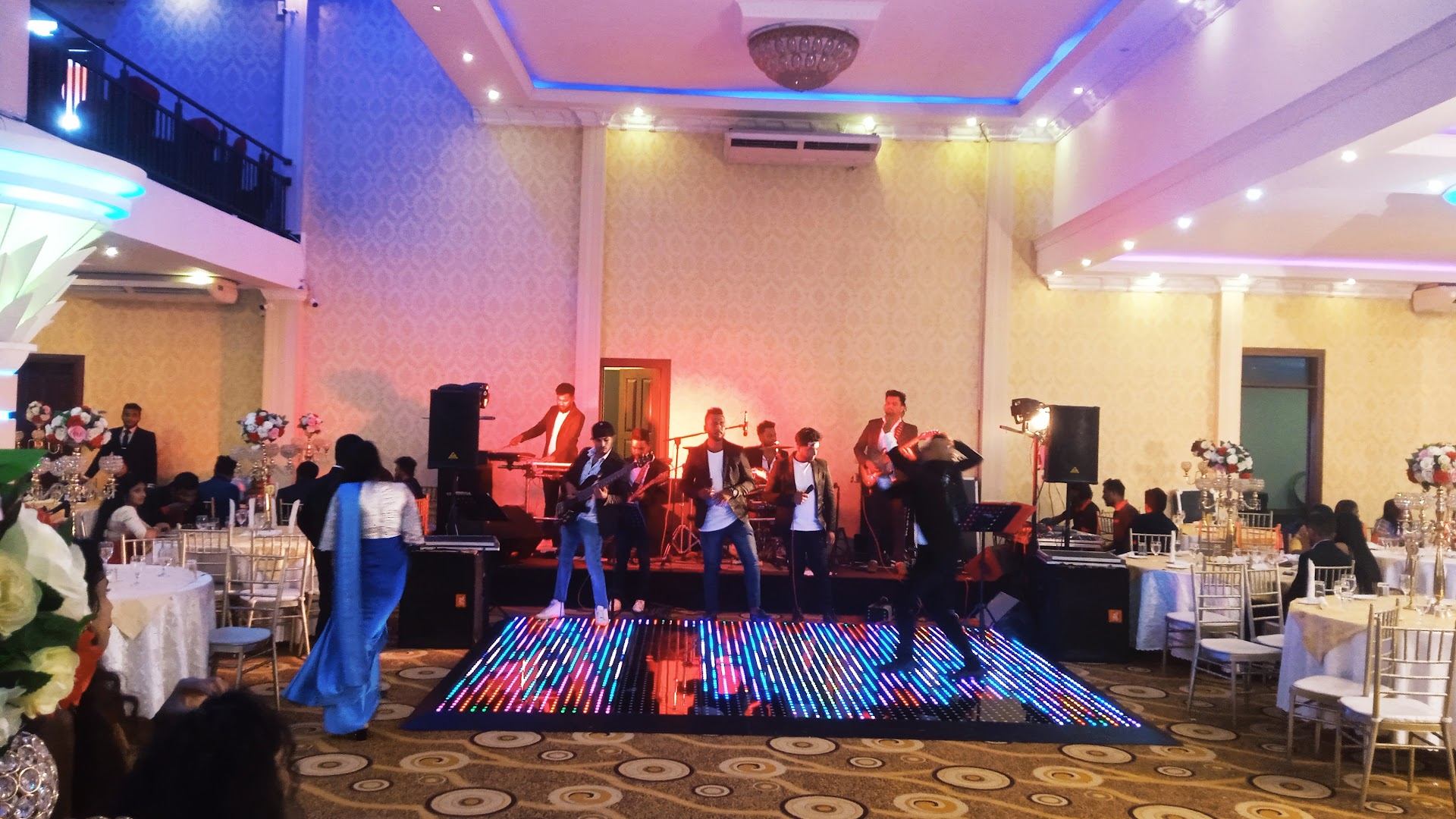 A live band playing beside a light-up dance floor